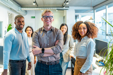 Startup team smiling in coworking office, multi ethnic professionals collaborating