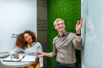 Managers discussing strategy in modern coworking office with green wall