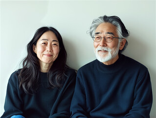 Happy senior Asian couple smiling together against a neutral background, aging gracefully and love in later life

