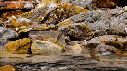 Close-Up of Weathered Rocks and Flowing Water in a Coastal Landscape
