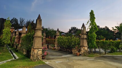 Elegant Stone Gate Entrance to a Scenic Garden at Dusk