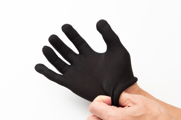 黒手袋をはめる男性の手