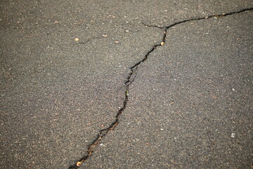 Obraz premium Cracks on grey asphalt close-up, old cracked asphalt close-up, old road surface bitumen 