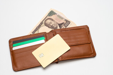 各種のクレジットカードと財布と一万円札