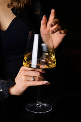 A girl holds a glass of white wine in her hands