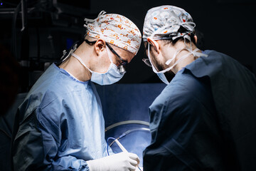 A team of professional surgeons performs surgery in a modern hospital. Concept skills working using...