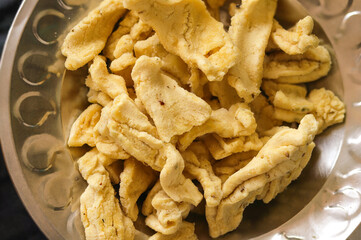 Selective Focus on Subject, Background Blur. danthal, Papdi, Are Deep Fried Snack Made From Chickpea Flour. Street food in an Indian Pouch, Bhavnagri Gathiya with Black Pepper, and Namkeen.