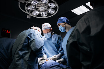 A team of professional surgeons performs surgery in a modern hospital. Concept skills working using...