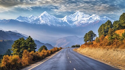 Stunning scenic road surrounded by golden hued trees and snow capped mountains in the himalayas © Daria