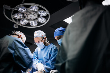 A team of professional surgeons performs surgery in a modern hospital. Concept skills working using...
