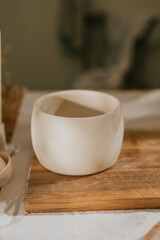 A white bowl sits on a wooden cutting board. The bowl is empty and the cutting board is made of wood