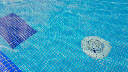 Plakat Cleaning of the drain valve filter at the bottom of the swimming pool, movement of clear water, top view