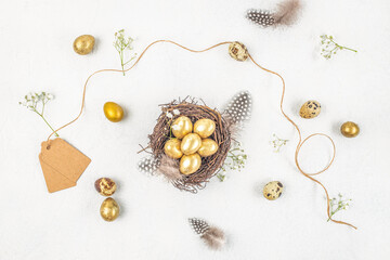 Easter quail eggs, nest and flowers on white background. Easter festive greeting card. Top view