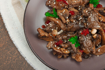Delicious Shimeji mushrooms with chili pepper, sesame seeds and greens. Healthy Umami vegan food