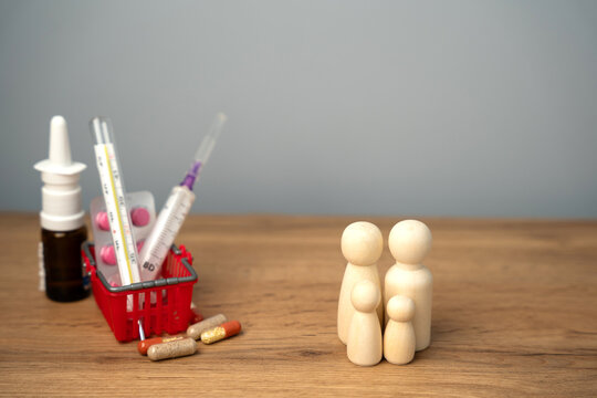 Figure of people near a basket with medical pills, a thermometer and a syringe. Concept of health insurance and family vaccination. Healthcare