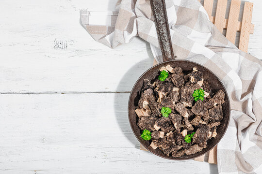 Raw black morel mushrooms with fresh parsley. Vegan ingredient for cooking healthy food