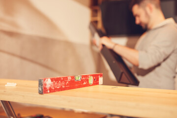 Handyman mounting new kitchen cabinets and shelf.