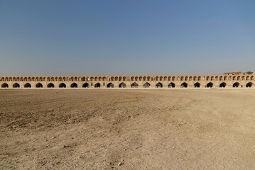 Khaju Bridge in Isfahan under blue sky.