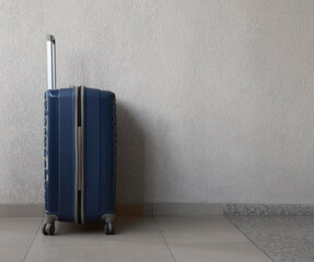 suitcase is standing near wall in hotel. side view. Traveling by airplane. baggage luggage stand on...