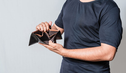 Hands of bankrupt person showing an empty wallet isolated. Man's hands in financial crisis showing...