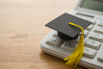 Mortarboard on calculator. Money financial management and planning for education, student debt or...
