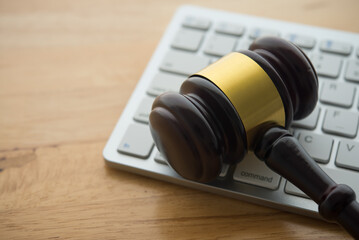 Judge hammer gavel on computer keyboard wooden table background. Online internet crime and scammer,...