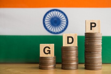 GDP (gross domestic product) character on growth stack coins with India flag background. South asia...