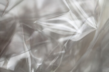Crumpled clear plastic background, abstract glossy broken surface texture with creases