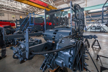 A factory worker assembles a combine harvester.