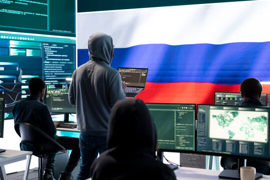 Propagandist person in a Russian cybersecurity center with the national flag works on installing fear and anxiety among the population by manipulation and brainwashing, cyber conflicts.