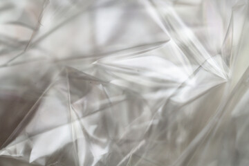 Crumpled clear plastic background, abstract glossy broken surface texture with creases