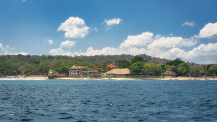 A serene and picturesque coastal landscape that showcases soft sandy beaches, vibrant lush foliage, and a stunning blue ocean beneath a beautifully partly cloudy sky, Nusa Lembongan, Bali, Indonesia