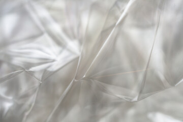Crumpled clear plastic background, abstract glossy broken surface texture with creases