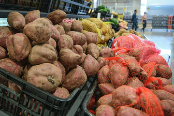 Sweet potato and potatos on display in a wholesale supermarket