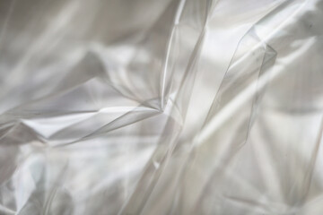 Crumpled clear plastic background, abstract glossy broken surface texture with creases