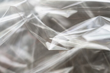 Crumpled clear plastic background, abstract glossy broken surface texture with creases