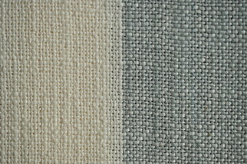 Fototapeta premium Striped fabric texture with beige, red, and gray colors. Textile background with woven pattern for fashion, design, and home decor projects. Natural cotton material close-up.