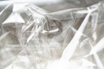 Crumpled clear plastic background, abstract glossy broken surface texture with creases