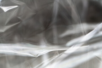 Crumpled clear plastic background, abstract glossy broken surface texture with creases