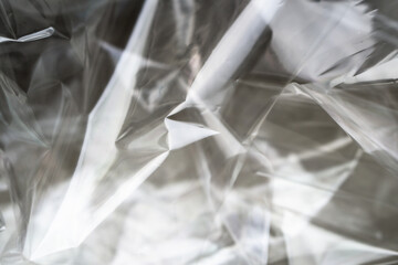Crumpled clear plastic background, abstract glossy broken surface texture with creases