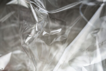 Crumpled clear plastic background, abstract glossy broken surface texture with creases