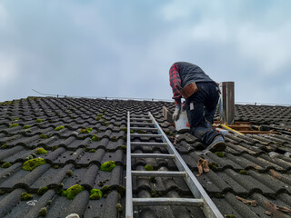 Roofer Installing a Stove Pipe – Working on a Roof with Ladder and Tools.