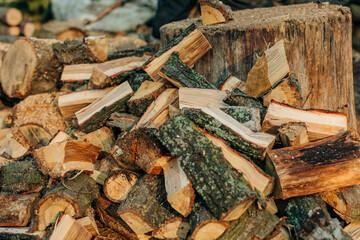 Carelessly stacked split wood logs in the yard after chopping