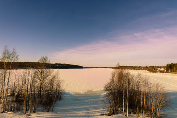 Golden Winter Sunset Over a Frozen Lake in Scandinavia