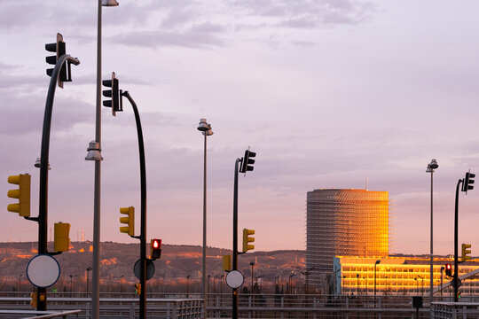 City skyline with illuminated traffic signals at sunrise in Zaragoza, Spain, blending urban infrastructure with the natural glow of dawn.