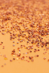 Glowing confetti scattered on a golden background. Selective focus.