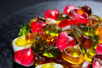 Assorted colorful gummy candies. Jelly sweets on stone plate