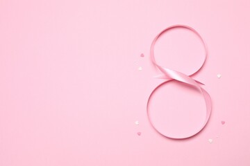 8 March, International Women's Day. Figure 8 is made of pink ribbon on a colored background. Space for text