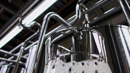 Fototapeta premium Golden craft beer streaming into glass inside sleek brewery, gleaming stainless steel equipment surrounding brewing process in professional industrial setting