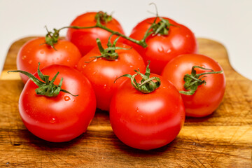 fresh tomatoes on a wooden chopping board
